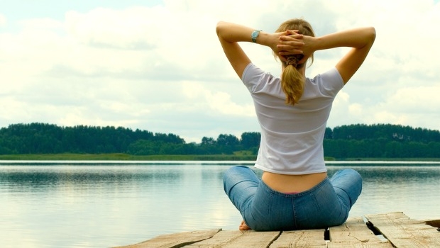 Mujer meditando junto al lago.